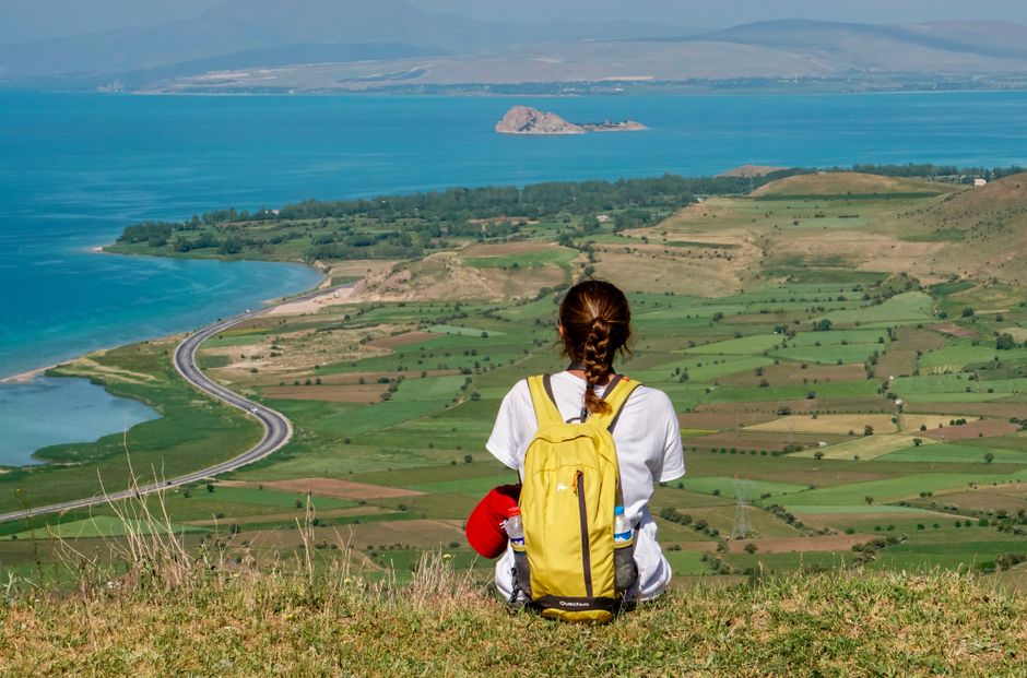 Woman sitting with view of Lake Van, Turkey, enjoying scenic nature and landscape.