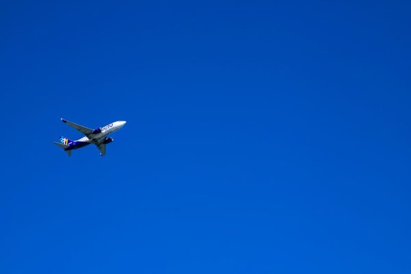 an airplane is flying in the blue sky