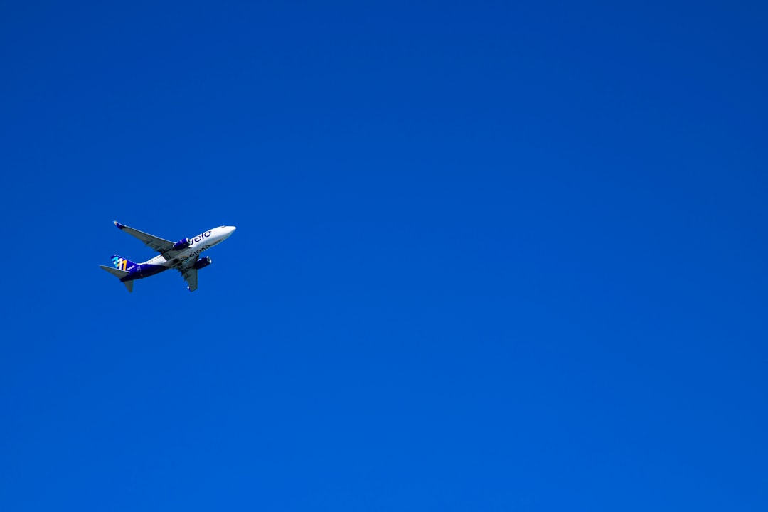an airplane is flying in the blue sky