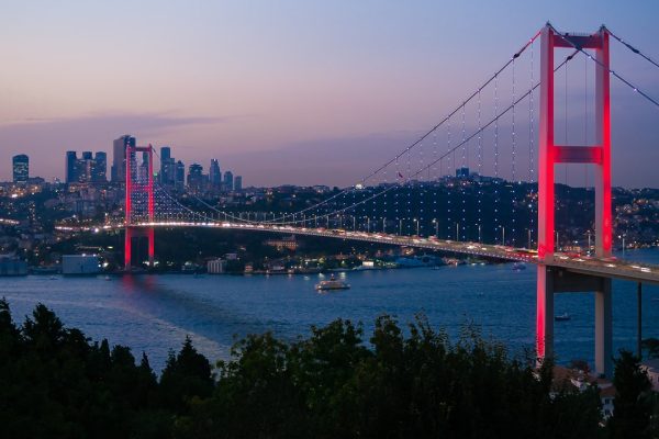 a bridge over a river with a city in the background
